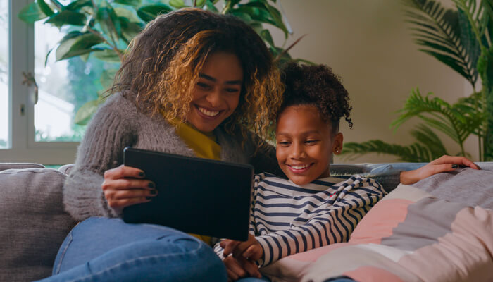 Mother and Daughter smiling looking at a tablet