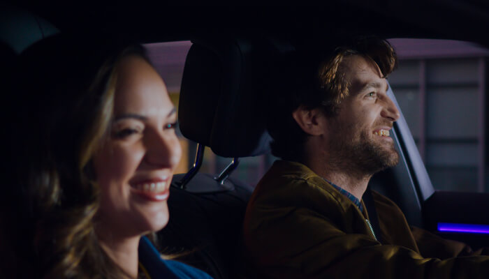 Man and woman smiling in a car