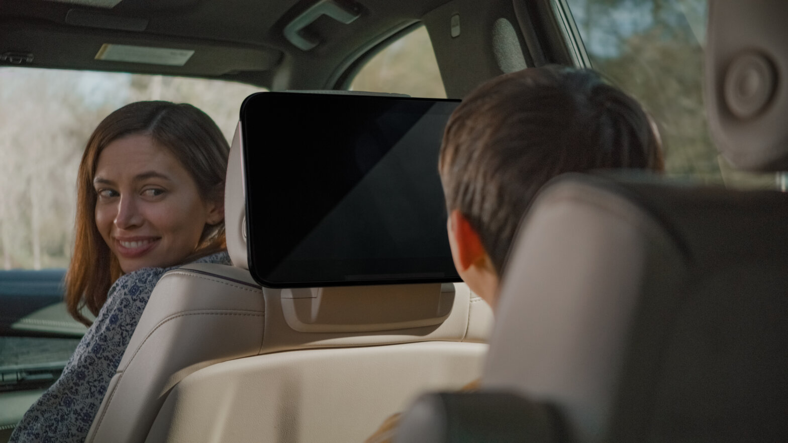 Family in a car watching a screen